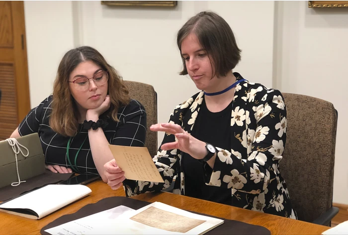 Two women looking at a piece of paper together