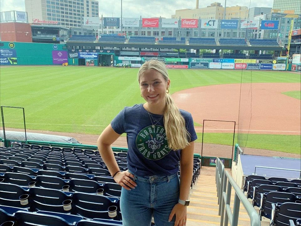 Bellisario College student Ashleigh Webb stands in Dunkin' Donuts Park, home to the Hartford Yard Goats, a AA minor league affiliate of the Colorado Rockies.