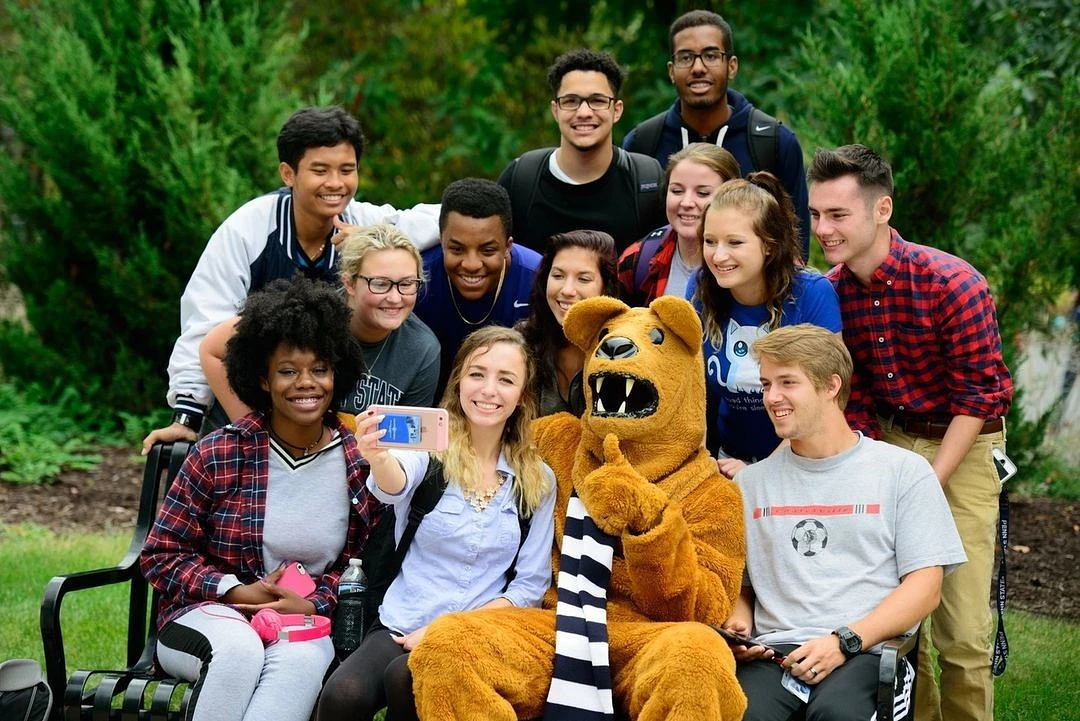 Students taking a selfie with the Nittany Lion
