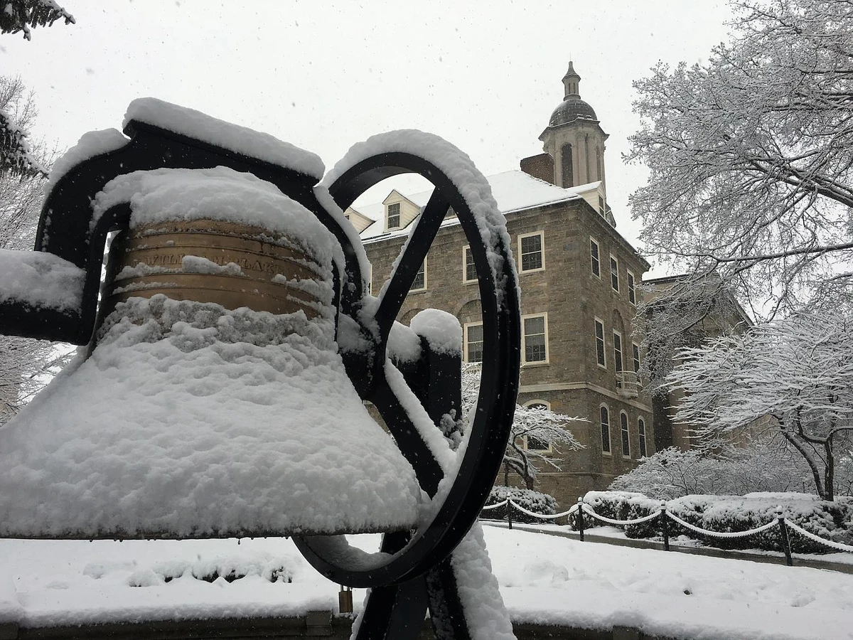 Bell outside of Old Main covered in snow.
