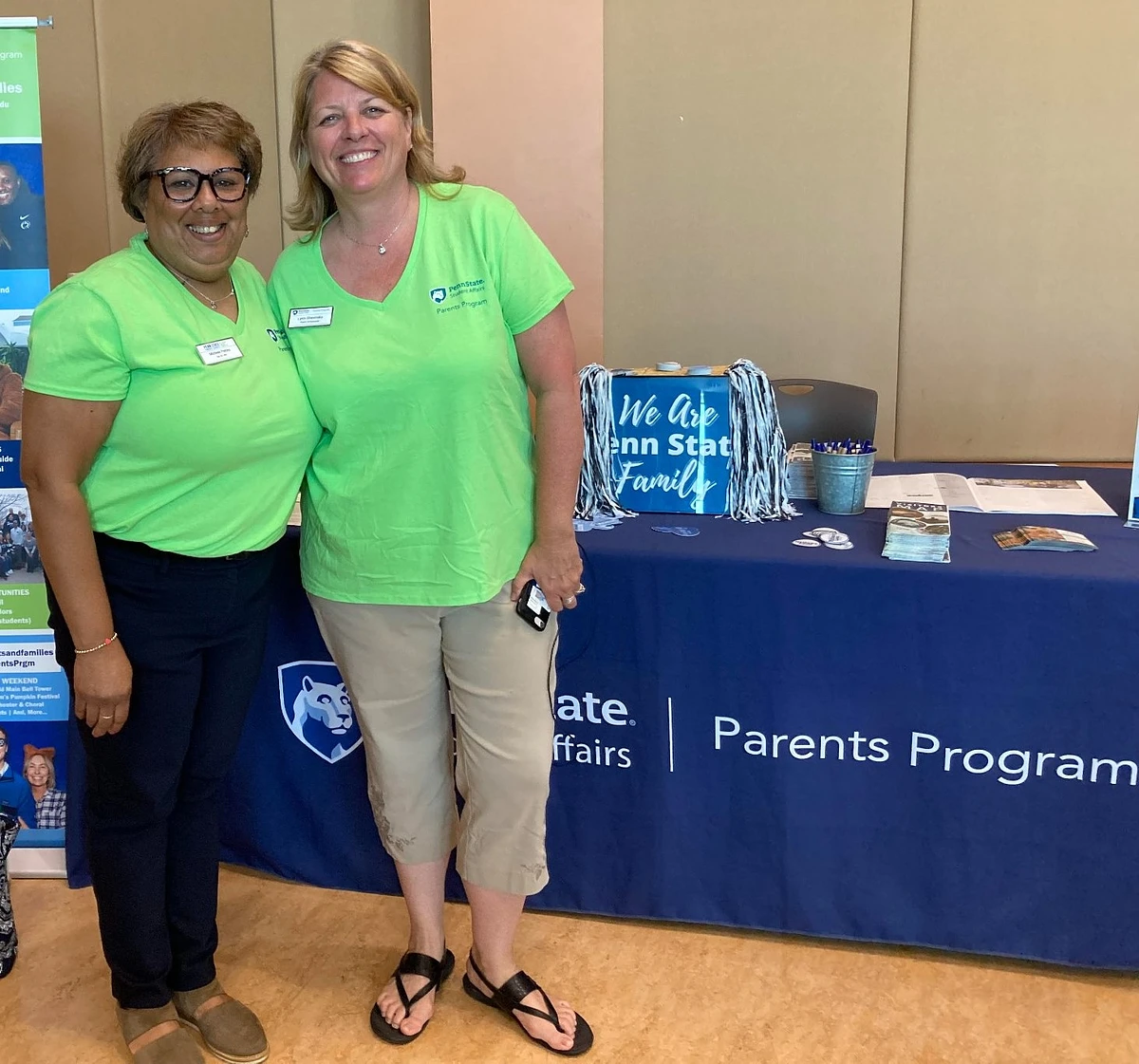 Two parent volunteers at a resource fair table. 